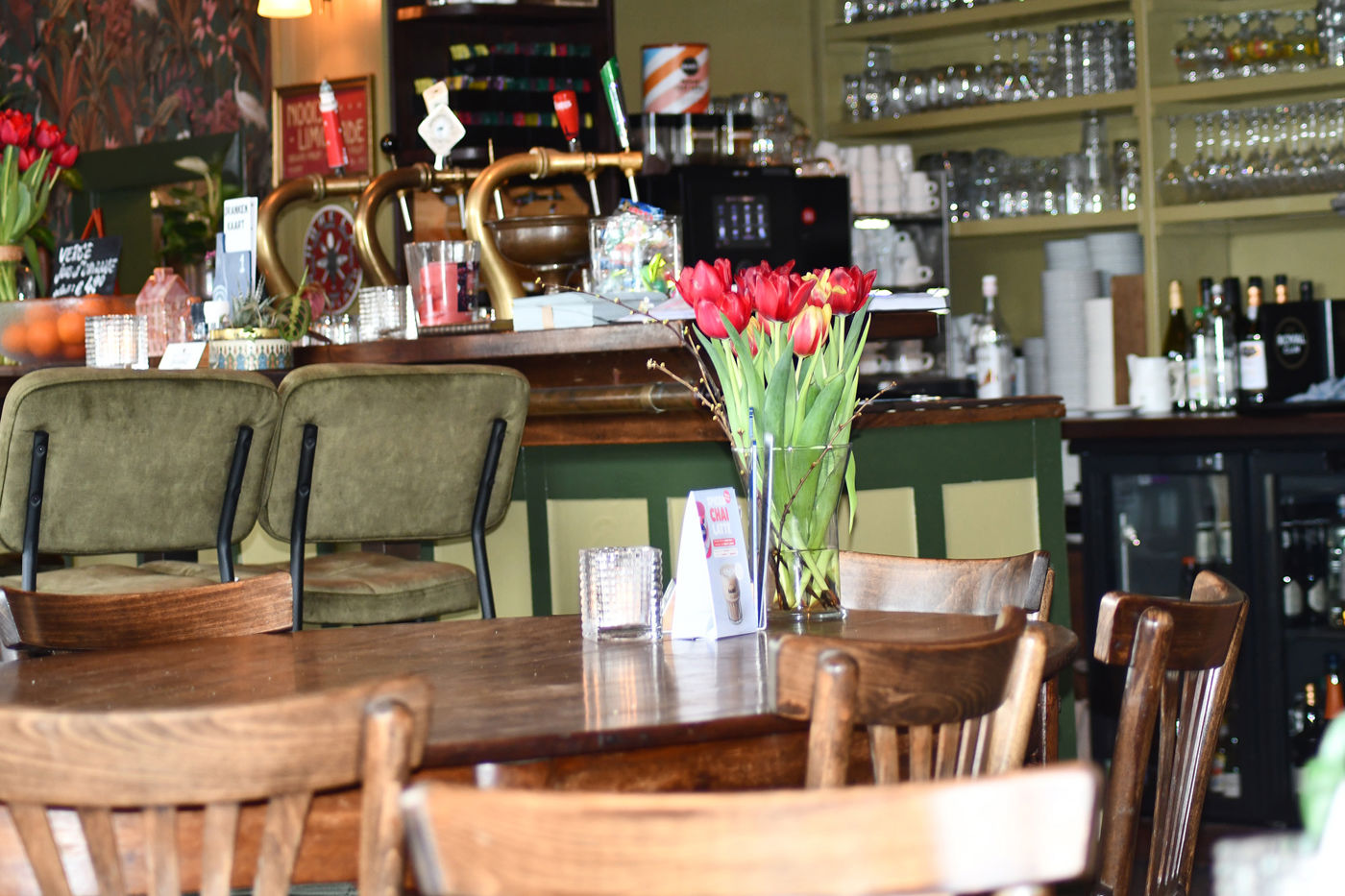 Les Deux Ponts interieur met gedekte tafels en stoelen en bar met tap Les Deux Ponts interieur met gedekte tafels en stoelen en bar met tap
