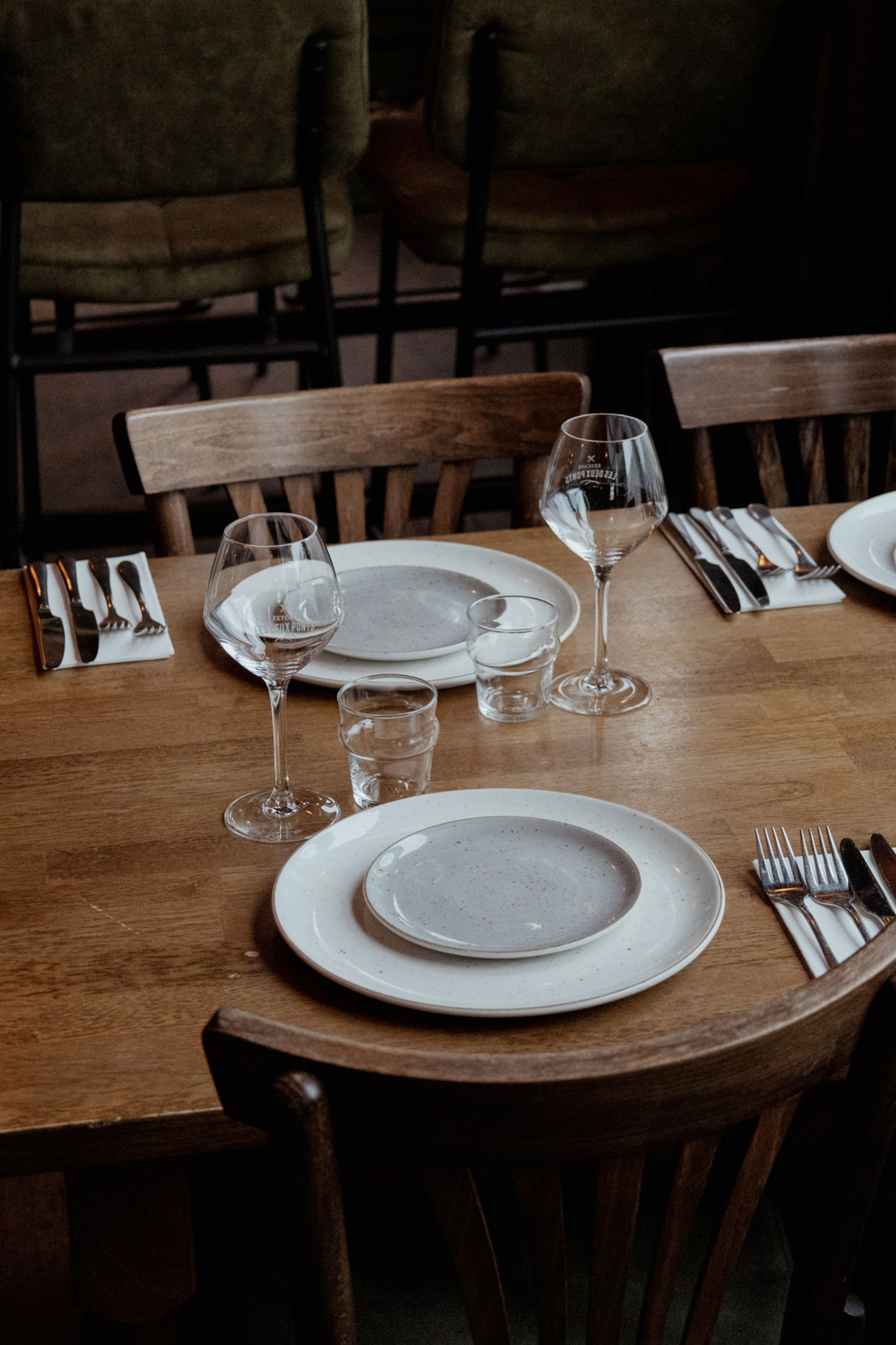 Restaurant interieur Les Deux Ponts Gedekte tafel met wijnglazen, borden en bestek
