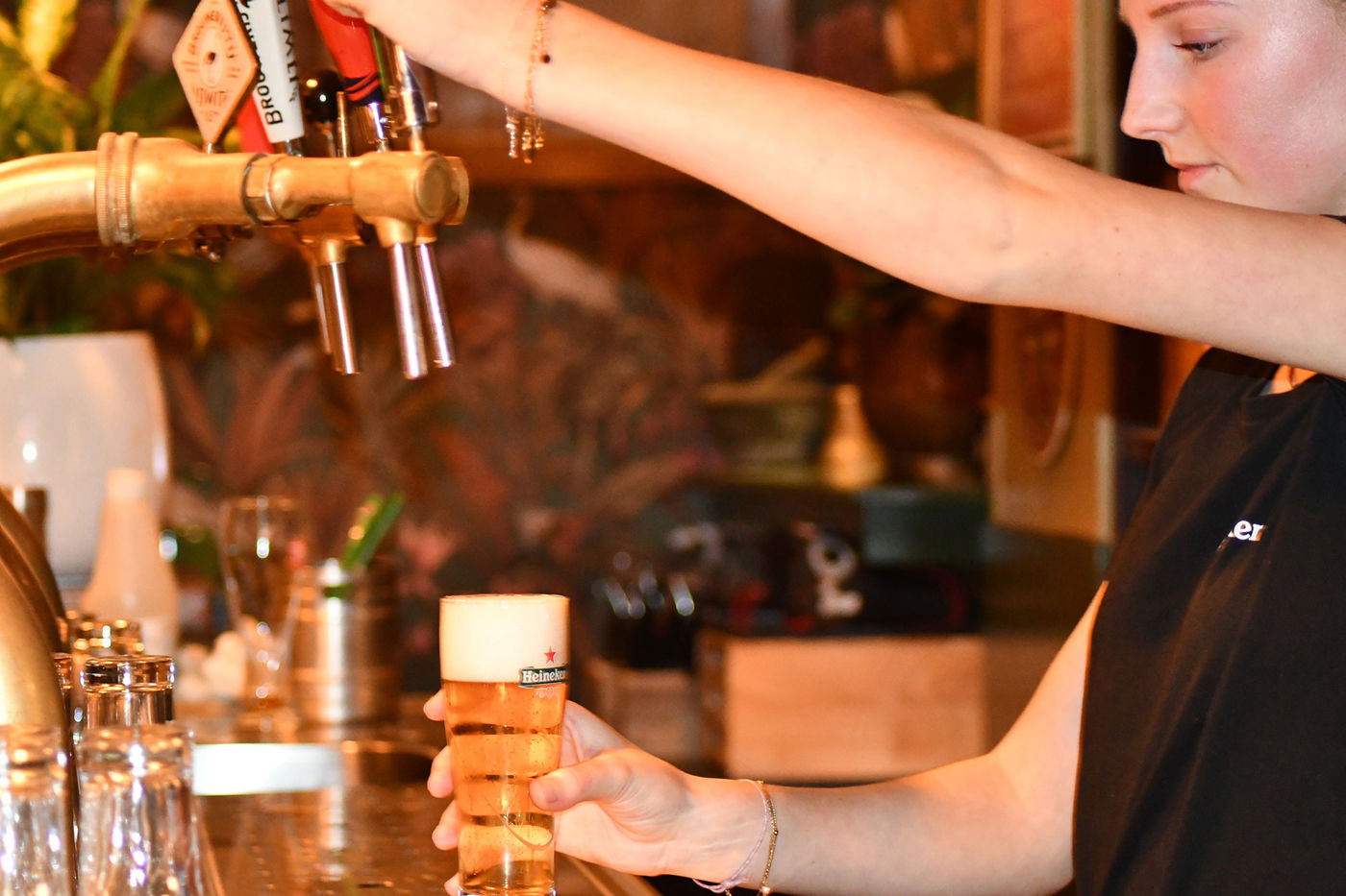 Les Deux Ponts barvrouw tapt biertje aan de bar